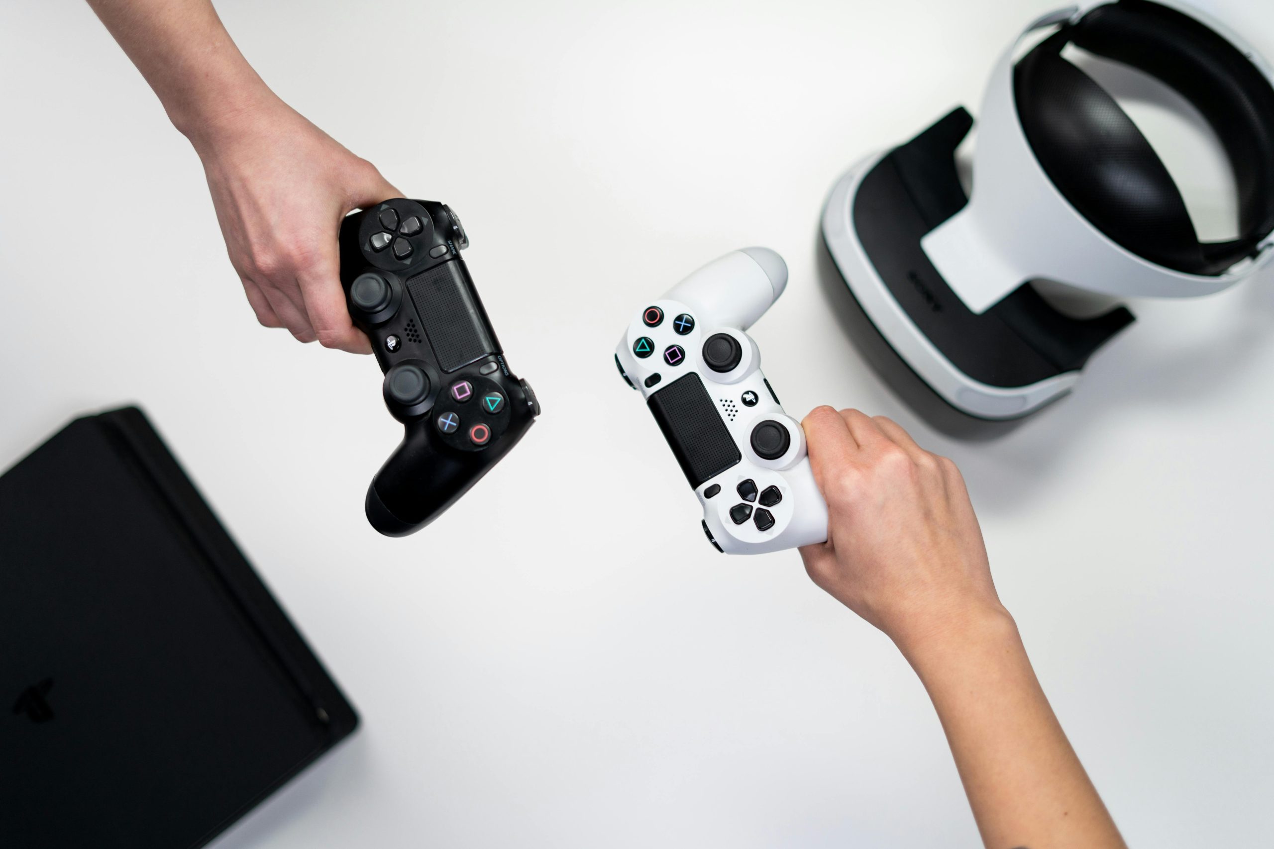 Two hands holding video game console controllers